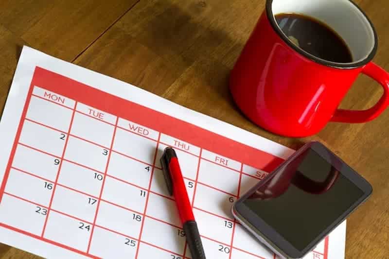 A calendar, coffee, and phone.